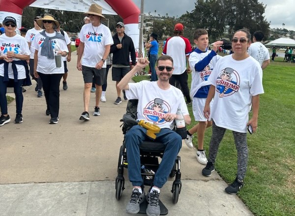 A man in a wheelchair is walking down the street